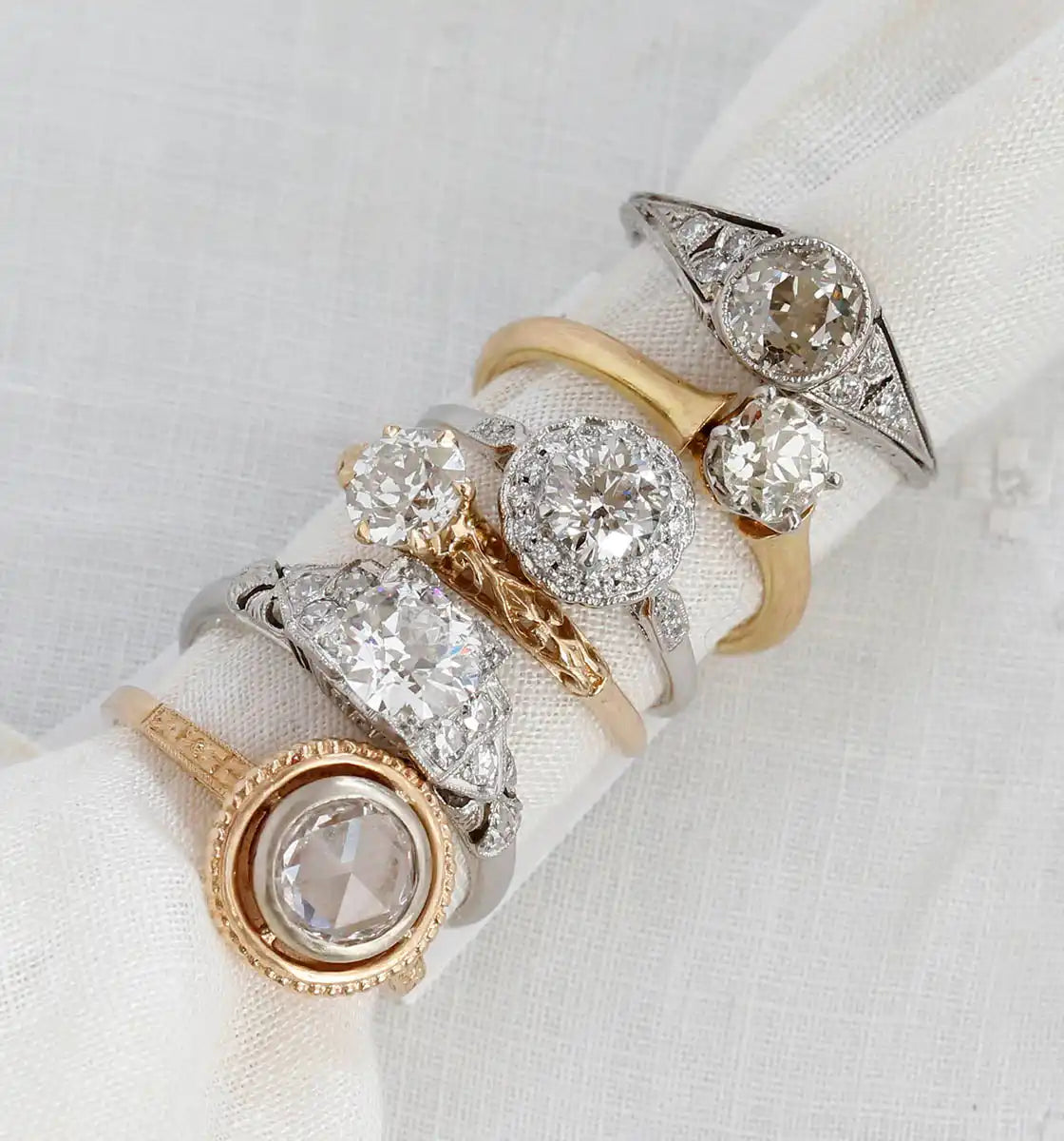 Collection of vintage-style diamond engagement rings in mixed gold and platinum settings.