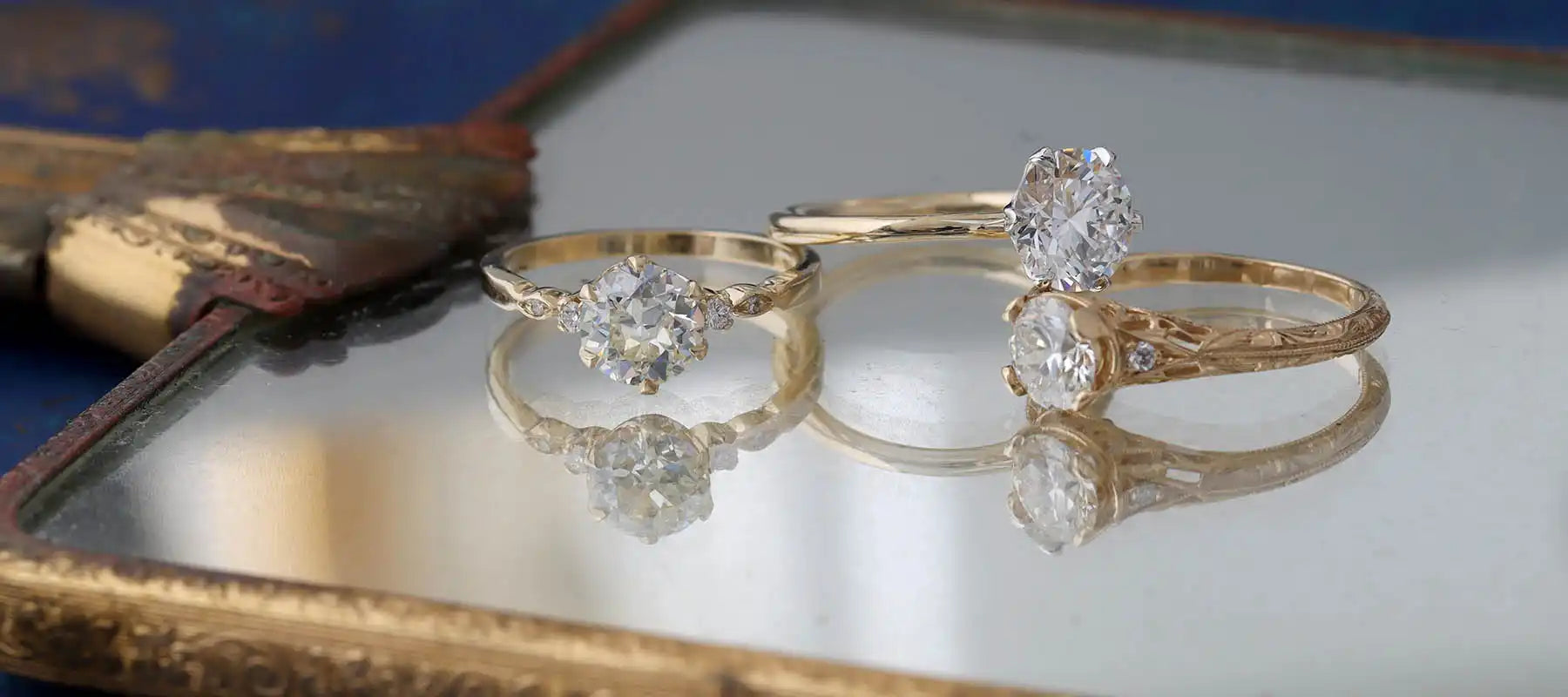 Two delicate gold rings with diamond settings displayed side by side.